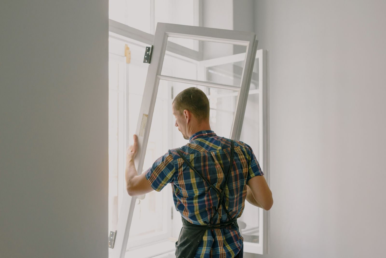 Profissional instalando janela em obra de reforma residencial